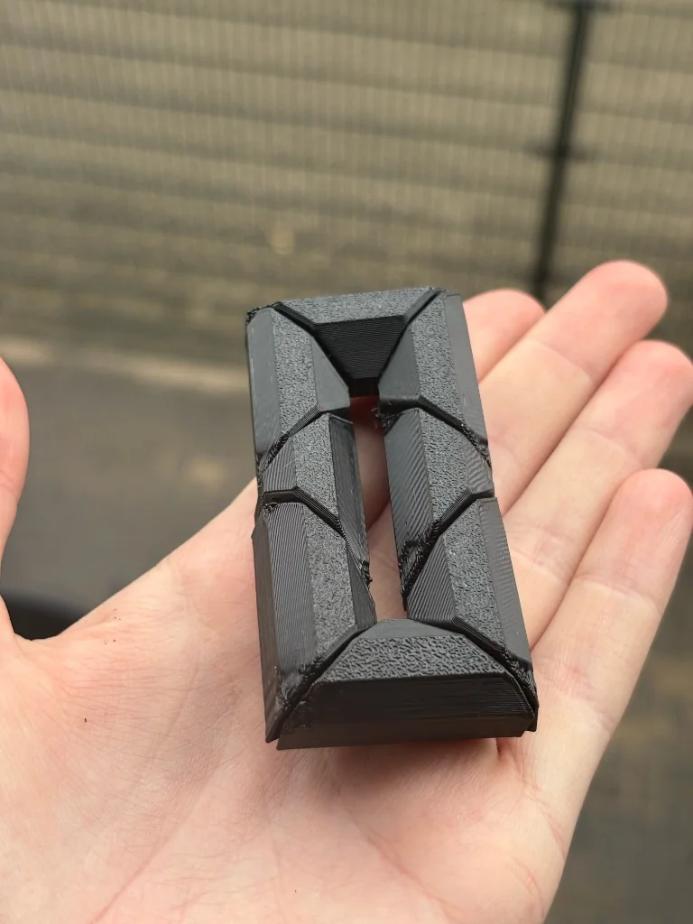 Matzwart 3D-geprint geometrisch object in een open hand